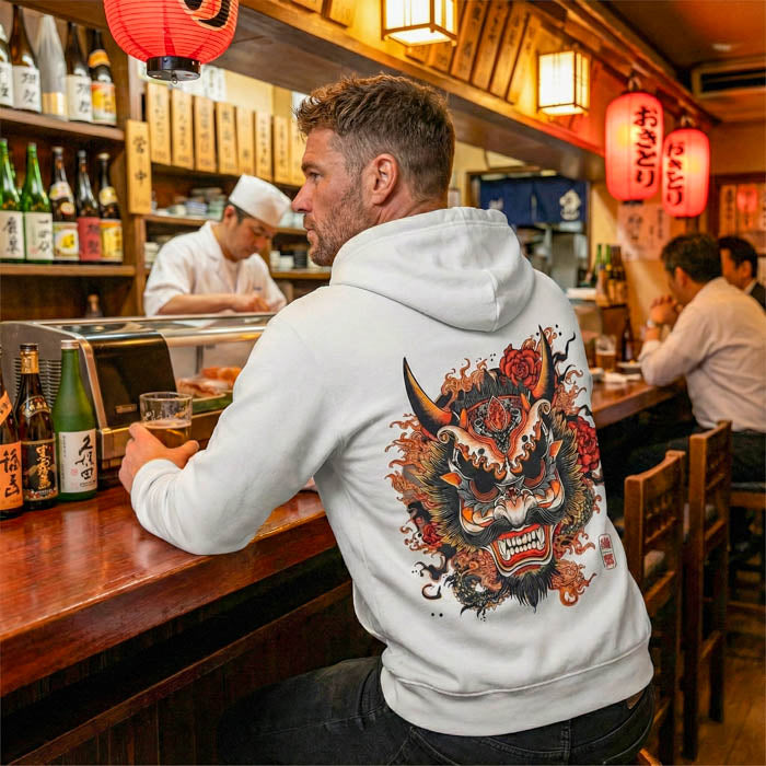 A high-quality flat-lay photo of the Oni Mask Hoodie on a concrete background.